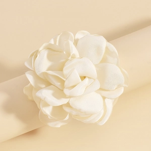 Détail d'un accessoire élégant en satin crème en forme de rose avec des pétales soyeux