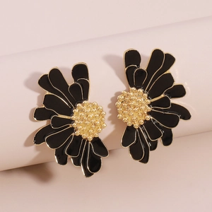 Macro detail of black enamel flower earrings with golden core and vintage texture