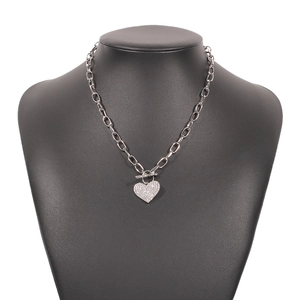Close-up of silver punk chain necklace featuring a pavé heart pendant and OT buckle toggle
