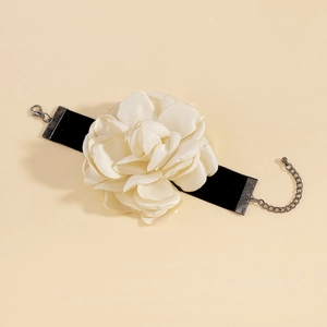 Détail d'un choker en velours noir orné d'une grande fleur de rose blanche en tissu 3D