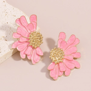 Detailed macro view of pink enamel flower earrings with golden textured metal stamens