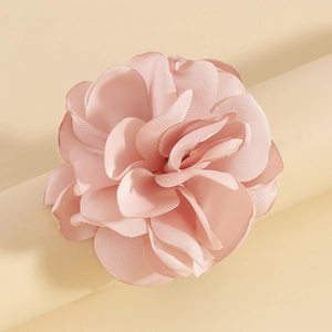 Détail macro du tour de cou élégant en velours rose clair avec pétales en tissu superposés