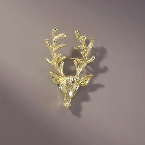 Détail de la broche tête de cerf dorée avec une texture métallique martelée d'art