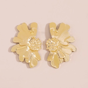 Detailed view of large gold floral earrings with intricate petal texture and metallic finish