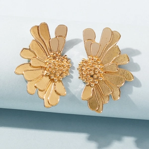 Macro shot of gold layered flower stud earrings showing detailed petals and textured center