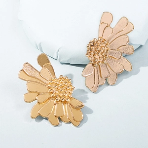 Detailed close-up of golden vintage layered flower earrings with textured petals