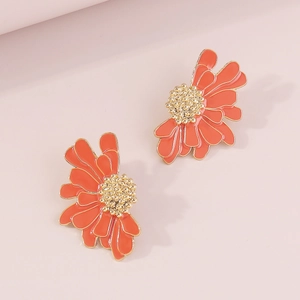 Macro detail of vintage orange flower stud earrings with golden metal edges and enamel