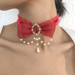 Detail of red lace choker with oval ruby pendant and hanging faux pearl chains