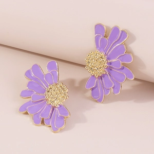 Macro shot of purple enamel daisy earrings with golden textured center and metallic edges