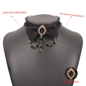 Detailed macro view of vintage bow choker with black lace, moon pendant and dark gemstone