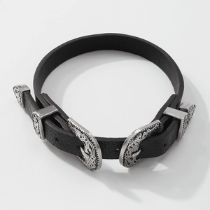Dettaglio del choker in pelle nera con fibbie argentate incise in stile western