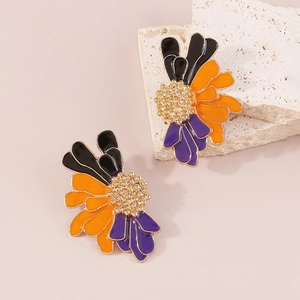 Detail of vintage enamel floral earrings featuring textured golden pistils on a stone base