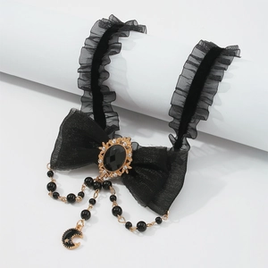 Detail of Gothic black velvet choker featuring mesh bow and golden moon star pendant