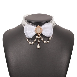Detail of white lace bow choker with faux pearl charms and pink gemstone on a black bust