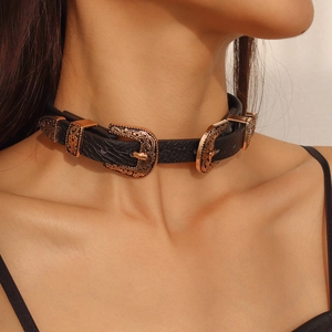 Dettaglio di un choker in pelle vintage con fibbie in bronzo goffrato e motivi floreali