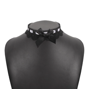 Macro detail of black lace choker with white ribbon and a large satin bow on mannequin