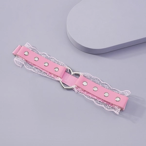 Détail de jarretière en cuir rose avec dentelle blanche, cœur et rivets argent