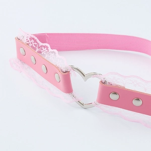 Détail d'un anneau de cuisse en dentelle rose avec clous argentés et cœur en métal