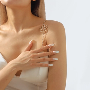 Detail of elegant gold shoulder chain with sparkling flower motifs and rhinestone accents