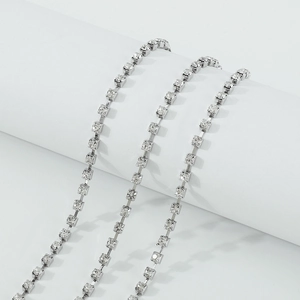 Gedetailleerde close-up van de dubbellaagse zilveren strass beenketting met kristal