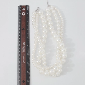 Detailed view of triple-layer pearl choker with lobster clasp and adjustable silver chain