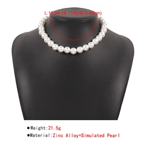 Detail showing faux pearl necklace sizing information and material specs on black mannequin