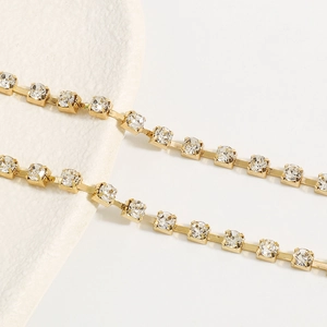 Detailopname van gouden strass-cupketting met fonkelende kristallen voor lichaamssieraden