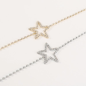 Macro shot of gold and silver star bracelets with sparkling crystal pavé settings