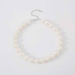 Detail of elegant pearl choker necklace featuring creamy white beads and silver metal clasp