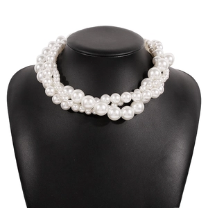 Detailed view of layered white faux pearls in varied sizes on a chic choker necklace