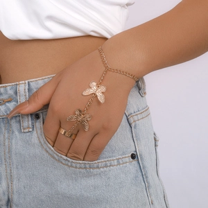Detail of gold slave bracelet featuring butterfly charms and ring-to-wrist chain design