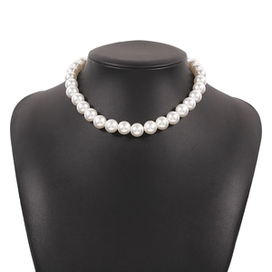 Close-up of elegant single strand white pearl choker necklace on a black display stand