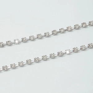 Macro shot of elegant silver rhinestone body chain with square claw-set crystals