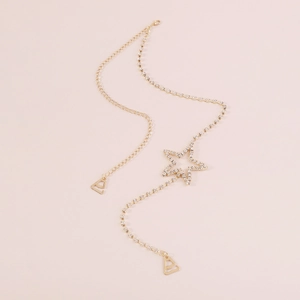 Macro shot of gold rhinestone body chain with a sparkling crystal star pendant and clasp