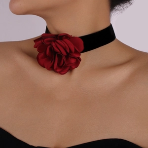 Gros plan d'une fleur de rose 3D en tissu sur un collier choker en velours noir