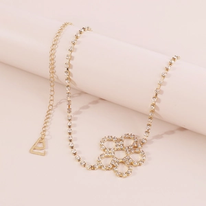 Detail of elegant gold rhinestone body chain with floral pendant and adjustable lobster clasp