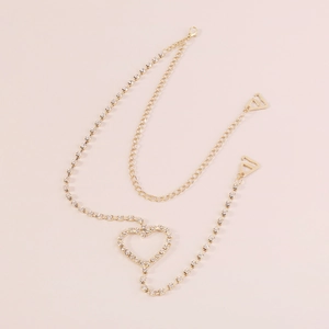 Detail of elegant gold double-layer body chain with heart rhinestone and metal hooks