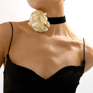 Gros plan d'un choker en velours noir orné d'une grande rose en tissu crème sur un mannequin