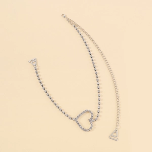 Detail of silver rhinestone shoulder strap featuring a sparkling heart-shaped pendant