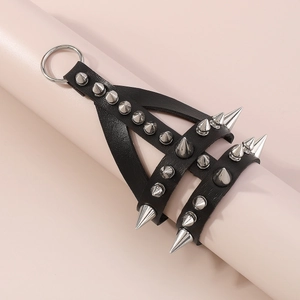 Detail of gothic punk black leather strap featuring silver conical studs and a metal ring