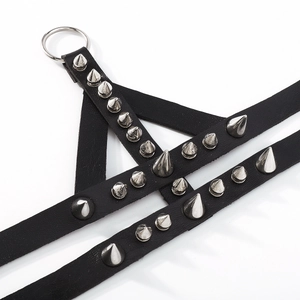 Close-up of black punk leather harness with silver conical metal spikes and O-ring