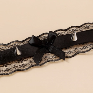 Detailed close-up of black floral lace choker with ribbon bow and silver metal rivets