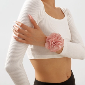 Élégante fleur de poignet rose en tissu avec pétales superposés sur une tenue de mode