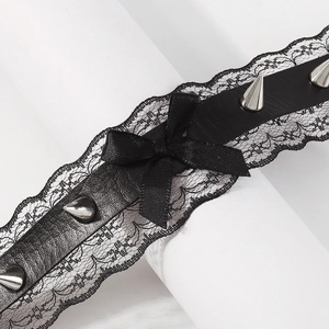 Close-up of black lace choker featuring metal rivets and a satin bow in punk style