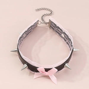 Detail of punk lace choker with pink satin bow and silver metallic spikes on black PU leather