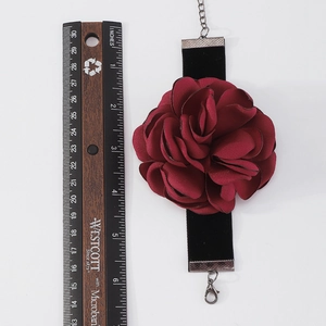 Détail macro du ras-du-cou fleur rouge foncé avec une règle pour mesurer les dimensions