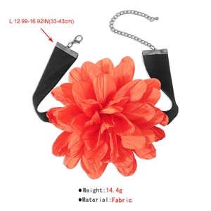 Détail d'un grand choker floral orange-rouge avec ruban en velours noir et fermoir argenté