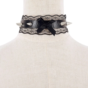 Close-up of black lace punk choker with metal spikes and ribbon bow on display