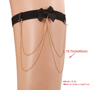 Detail of black elastic thigh garter with bow and three-layer gold chain tassel