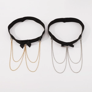 Detail of sexy black elastic leg garters with bow accent and gold or silver chain fringe